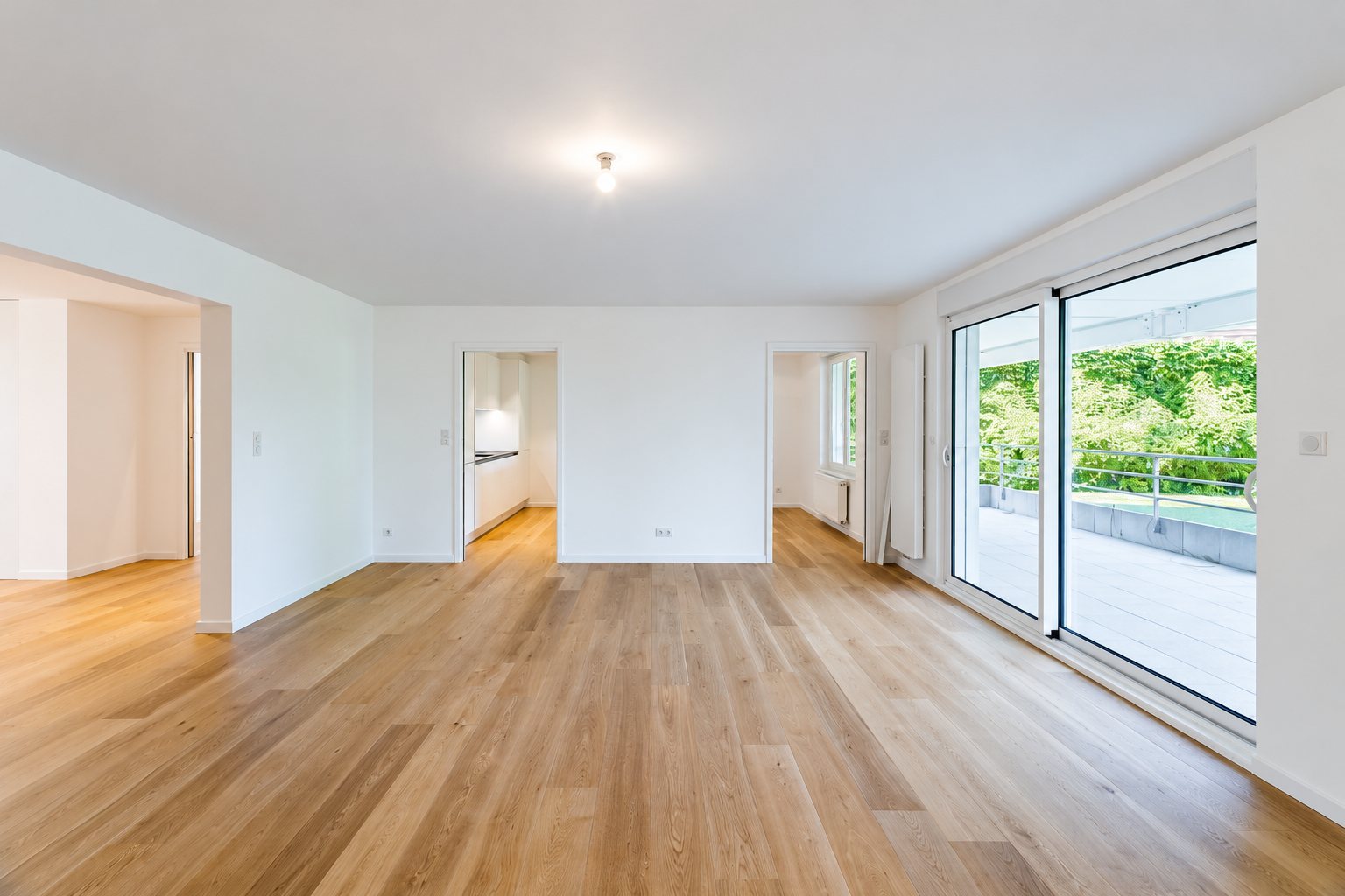 Réalisation KPAG, appartement vide rénové avec parquet en chêne et baie vitrée sur terrasse